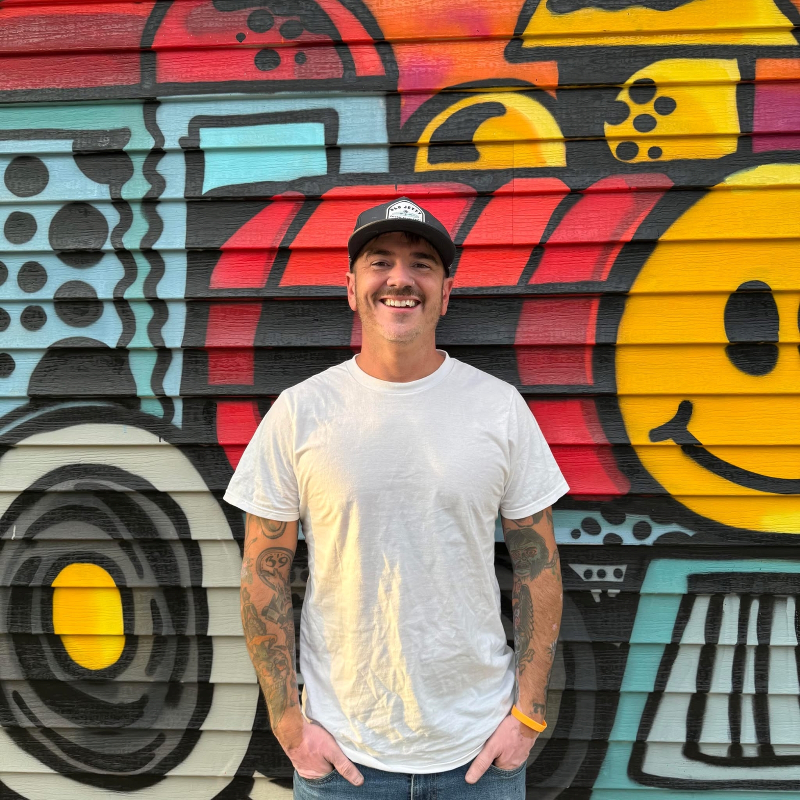 The artist in front of Mural